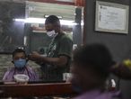 AME4443. RÍO DE JANEIRO (BRASIL), 21/04/2020.- Un barbero de la favela de Mandela trabaja con tapabocas este martes durante la pandemia COVID-19, en la zona norte de Río de Janeiro (Brasil). EFE/Antonio Lacerda