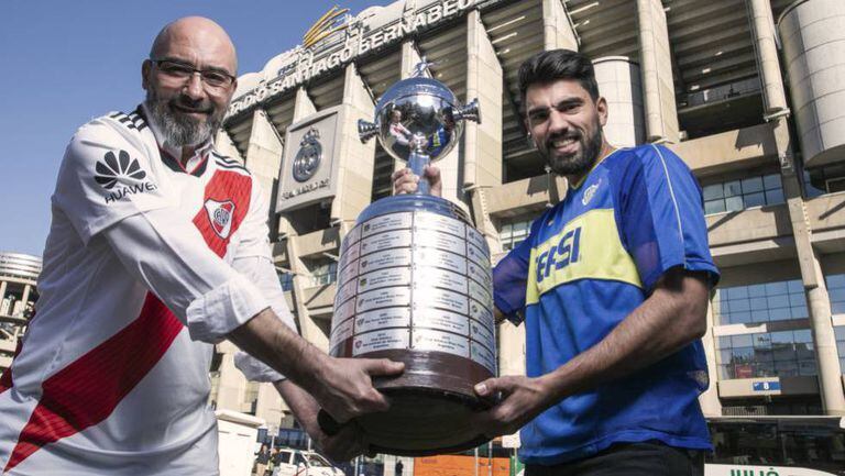 Fabio Vides e Leonardo Polzello, torcedores do River e Boca, posam com uma réplica da Taça Libertadores no Santiago Bernabéu.