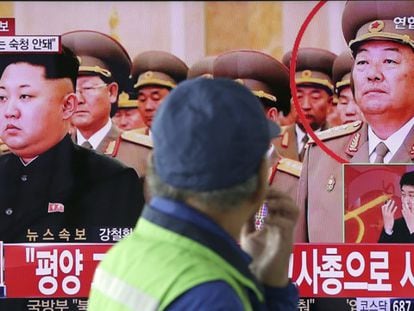 Homem observa TV que informa a morte do ministro de Defesa norte-coreano.