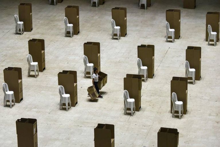 Uma mulher transporta na sexta-feira cabines de votação em um colégio eleitoral de Cali.