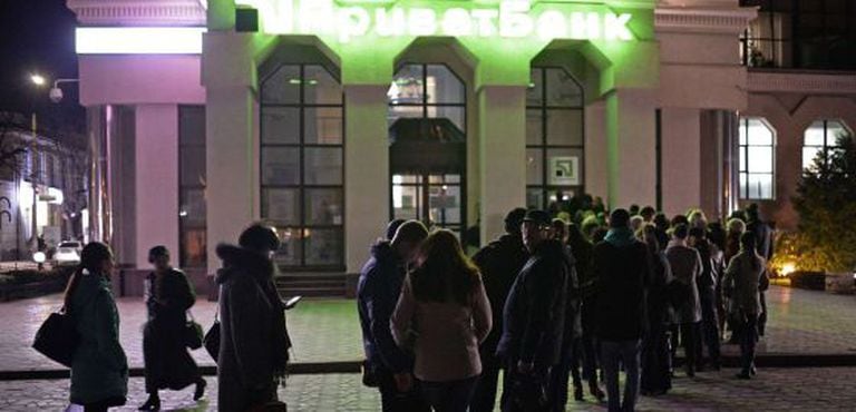 Várias pessoas à espera de retirar dinheiro de um caixa, em Simferópol.