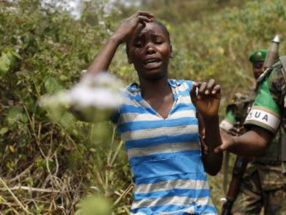 Uma mulher aterrorizada é conduzida por um soldado nos arredores de Bangui, capital da República Centro-Africana.