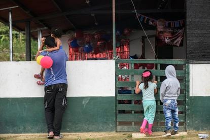 Um homem e um grupo de crianças observam o restaurante comunitário da Área de Treinamento e Reincorporação Territorial (ETCR) em Icononzo, no dia 17 de novembro.