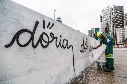 Funcionário da Prefeitura apaga pichação com nome de Doria.