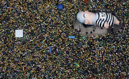 Manifestantes levantam o boneco que remete ao ex-presidente Lula, na avenida Paulista, no domingo (13).