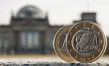 Duas moedas de um euro, uma delas cunhada na Grécia, fotografadas diante do parlamento alemão, em Berlim.