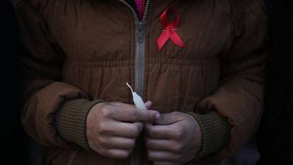 Mulher carrega o símbolo da luta contra a AIDS no mundo, em um centro de reabilitação de vítimas de tráfico sexual no Nepal.