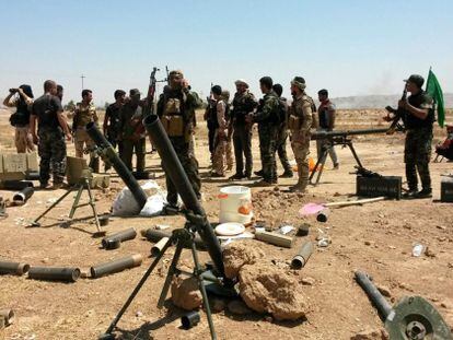 Soldados das forças curdas de Peshmerga e voluntários xiitas tomam posições em Amerly, no noroeste de Bagdá, em 7 de agosto.