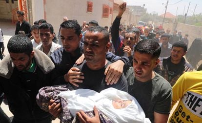 Pai de menina morta por um projétil leva a filha para o funeral, neste domingo, em Gaza.