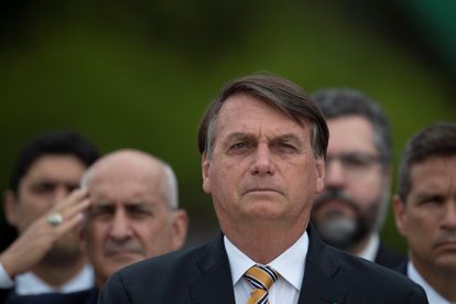 O presidente Jair Bolsonaro em Brasília. Ao fundo, o General Ramos, ministro chefe da Secretaria de Governo, bate continência.