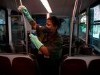A worker disinfects handrails of the Corcovado hill train, which is taken by tourists to go up to see the statue of Christ the Redeemer in Rio de Janeiro, Brazil, on March 17, 2020. - Rio de Janeiro's state government closed the iconic Christ the Redeemer statue and the cable car to Sugarloaf Mountain, two of the city's most famous attractions, as an emergency measure to stop the spread of the new coronavirus COVID-19. (Photo by MAURO PIMENTEL / AFP)