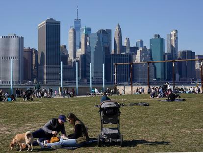 Cidadãos relaxam no bairro nova-iorquino do Brooklyn, com Manhattan ao fundo, no domingo passado.