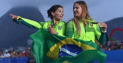 Martine e Kahena seguram a bandeira do Brasil no pódio.