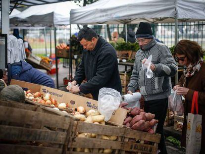 Grupo de pessoas compra numa feira de Buenos Aires.