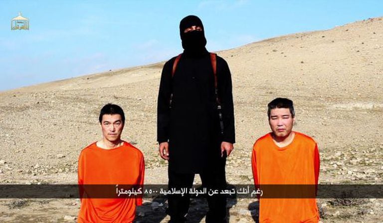 Imagem de um vídeo divulgado pelo Estado Islâmico com dois reféns japoneses, vigiados por John, o jihadista.