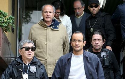 Os empreiteiros Marcelo Odebrecht (de óculos) e Otávio Marques Azevedo escoltados por policiais, em Curitiba.