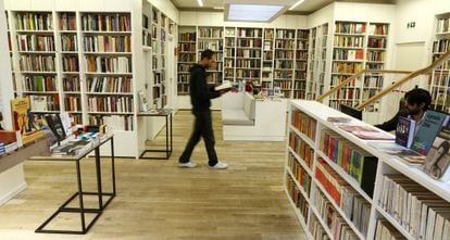 Homem caminha enquanto lê um livro na livraria Juan Rulfo, em Madri.