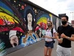 Tourists from France wear face masks as they walk past the East Side Gallery, the largest remaining part of the former Berlin Wall, following the coronavirus (COVID-19) disease outbreak in Berlin, Germany, June 27, 2020.    REUTERS/Fabrizio Bensch