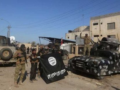Forças iraquianas mostram vitoriosas uma bandeira do ISIS depois de recuperar Ramadi.