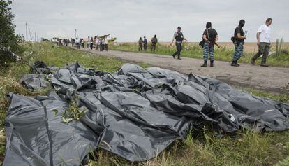 Rebeldes pró-russos ao lado dos corpos das vítimas do MH17, em julho.