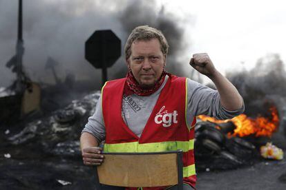 Um sindicalista olha para a câmera após criar uma barricada para impedir o acesso a uma refinaria durante a greve em Douchy les Mines, norte da França.