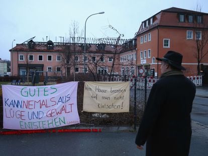 Um homem diante de faixas de protesto contra o incêndio de um hotel, na segunda-feira em Bautzen (Alemanha).