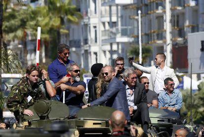 Domingo, 18 de maio de 2014. Em três tanques, passeiam por Cannes, entre outros, Sylvester Stallone (de pé, primeiro à esquerda), Mel Gibson (de barba), Wesley Snipes (de costas), Jason Statham, Harrison Ford, Arnold Schwarzegenner e, à direita da imagem, Antonio Banderas.