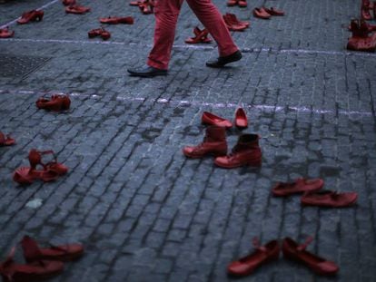 Um homem caminha entre sapatos femininos em um protesto contra a violência machista em Barcelona (Espanha), na segunda-feira.