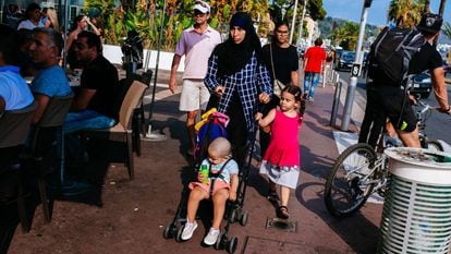 Muçulmana usando véu passeia com seus filhos na cidade francesa de Nice.