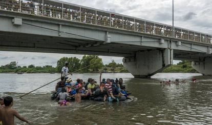 Migrantes cruzam em balsa o rio Suchiate para chegar ao México.