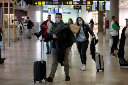 Passageiros procedentes da Itália chegam com máscaras no aeroporto de Manises, em Valência, na Espanha.