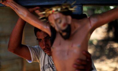 Homem carrega est&aacute;tua de Jesus Cristo antes de prociss&atilde;o em El Salvador. 