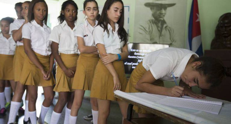 Estudantes assinam o livro de condolências de Fidel Castro.