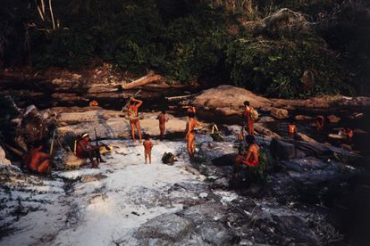 Um grupo de indígenas araweté na margem de um rio após um dia de caça.