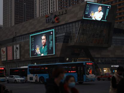 Uma rua da cidade chinesa de Shenyang, nesta quarta-feira. Nas telas, um programa de homenagem aos médicos que viajaram a Wuhan.