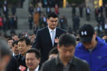 O ex-astro do NBA Yao Ming, rodeado de compatriotas (com cabelo), a caminho do Congresso Nacional em Pequim, em março de 2017.