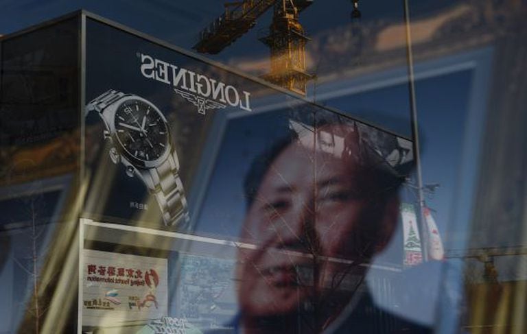 Propaganda reflete em vitrine que expõe foto de Mao Tsé-Tung.