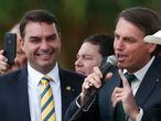 FILE - This Nov. 21, 2019 file photo shows Sen. Flavio Bolsonaro, left, with his father Brazilian President Jair Bolsonaro at the launch of his father's new political party Alliance for Brazil in Brasilia, Brazil. Public prosecutors in Rio de Janeiro state have indicted Sen. Flávio Bolsonaro for allegedly commanding a criminal organization and laundering money when he was a state lawmaker between 2007 and 2018, according to a statement the public prosecutors’ office posted to its website on Wednesday, Nov. 4, 2020. (AP Photo/Eraldo Peres, File)