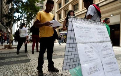 Pessoas procuram vagas de empregos em cartazes no centro de São Paulo.
