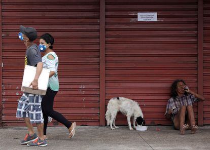 Pessoas com máscaras protetoras andam durante o surto de doença de coronavírus, perto do Porto de Manaus.