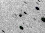 El cometa 2014 UN271 (el círculo del centro de la imagen), rodeado de estrellas, que aparecen alargadas por el movimiento del telescopio.