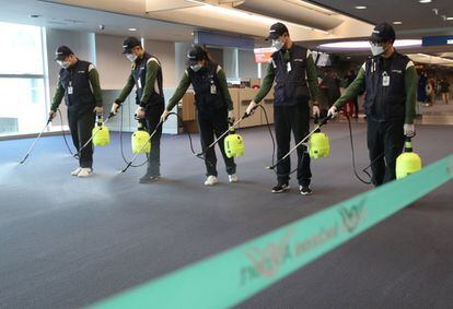 Operários desinfetam a zona alfandegária do aeroporto internacional de Incheon (Coreia do Sul).