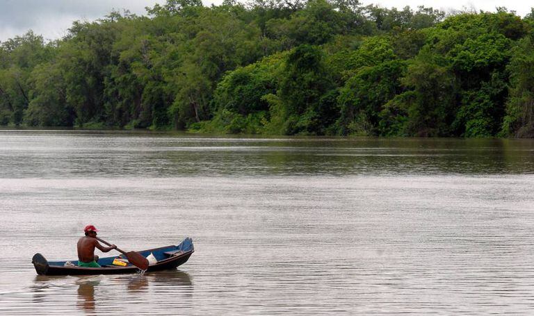 Homem rema em uma balsa na Amazônia brasileira.