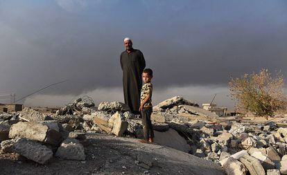 Salih Latif e um de seus filhos na montanha de escombros que restou de seu lar em Haji Ali.