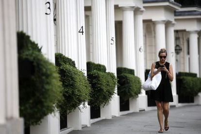 Mulher caminha por uma zona residencial de luxo em Londres.