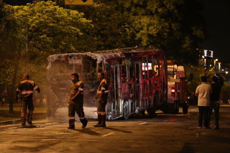 Técnicos retiram ônibus incendiado na zona norte de São Paulo.