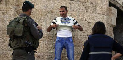 Policiais revistam palestino no Portão de Damasco, em Jerusalém.
