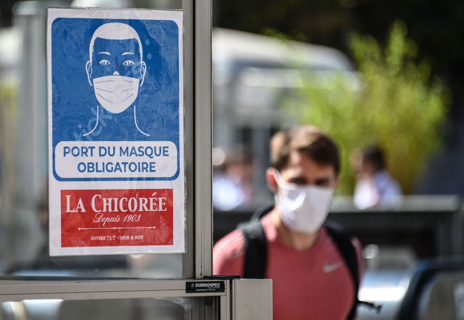 Homem caminha próximo a aviso de obrigatoriedade do uso de máscaras el locais fechados em Lille, no norte da França. 