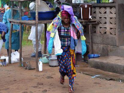 Uma mulher carrega os pertences de seu esposo, vítima do ebola, na Libéria.