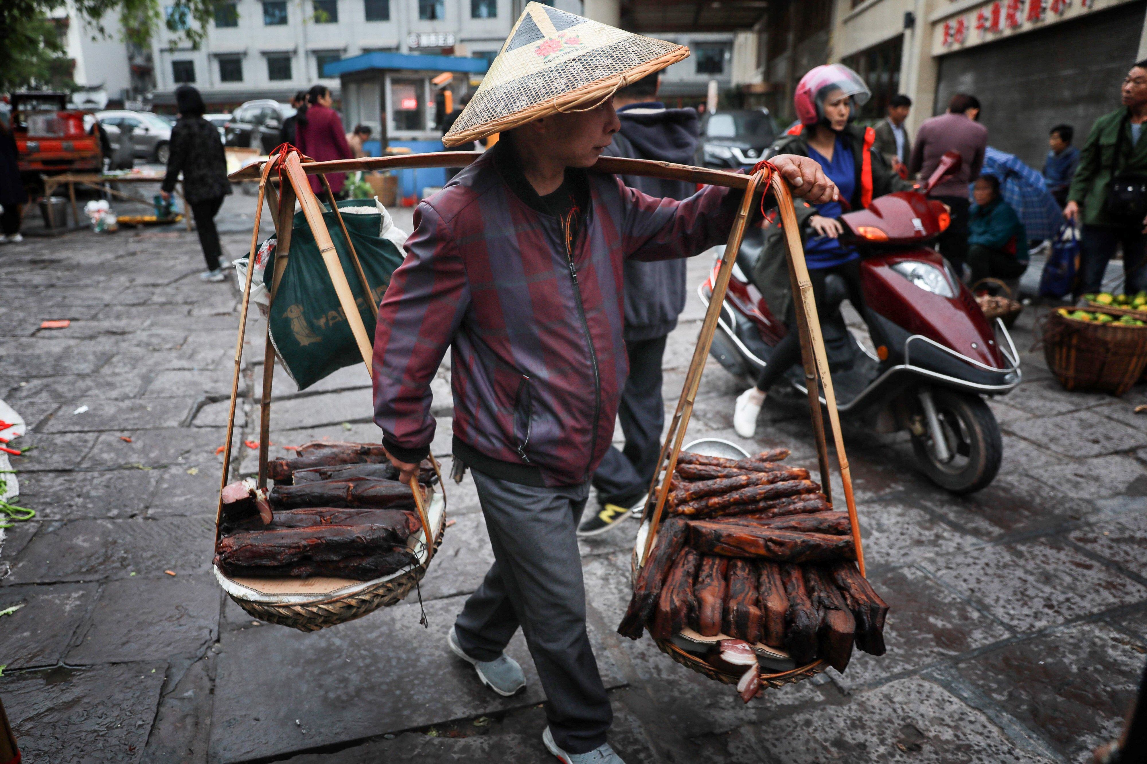 Vendedor ambulante trabalha na cidade velha de Fenghuang em Xiangxi, na China central. 